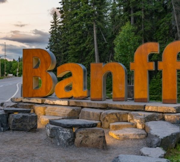 Großes, rustikales Ortsschild mit der Aufschrift 'Banff' aus Metall und Stein.