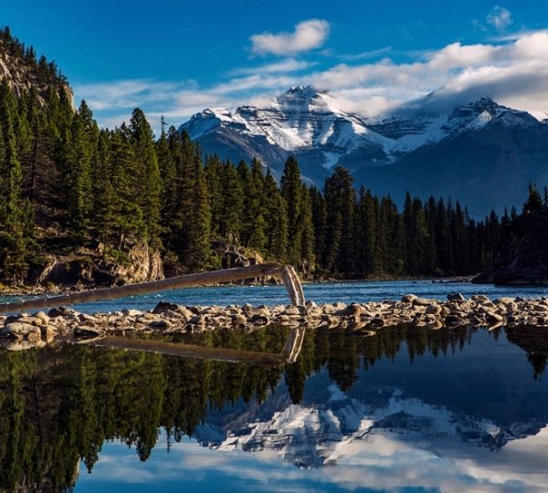 Bow River mit Bergen im Hintergrund und reflektierenden Wasserflächen im Banff Nationalpark.