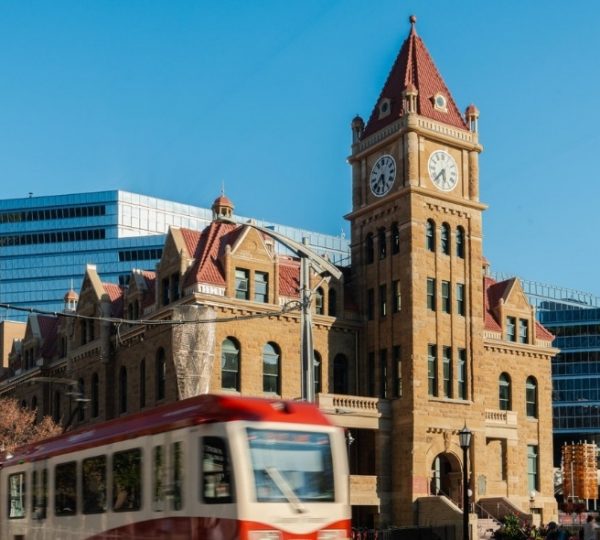 Historisches Gebäude mit einem Uhrturm und moderner Architektur im Hintergrund in Calgary.