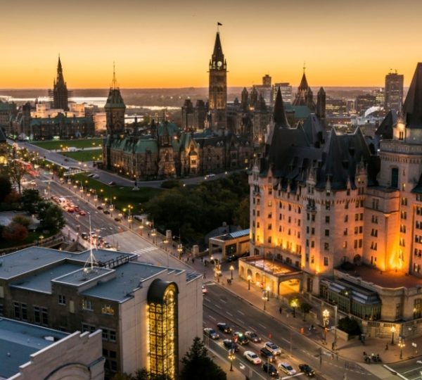 Panoramablick auf die Stadt Ottawa mit historischen Gebäuden und Straßen bei Sonnenuntergang.