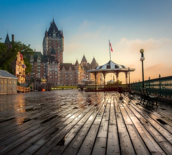 Holzplanken mit einem Pavillon und historischen Gebäuden im Hintergrund in Quebec City.