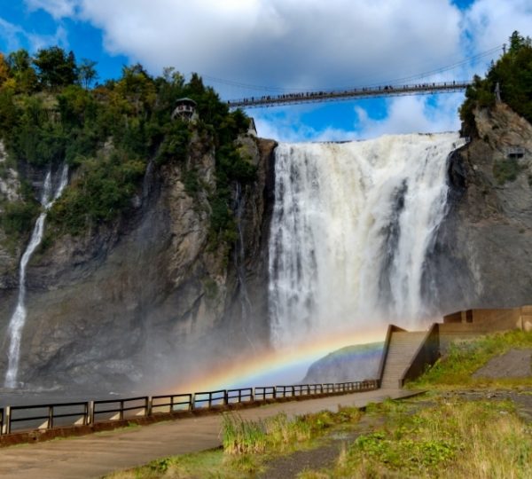 Montmorency Wasserfall mit Regenbogen und Brücke im Hintergrund in Quebec, Kanada.
