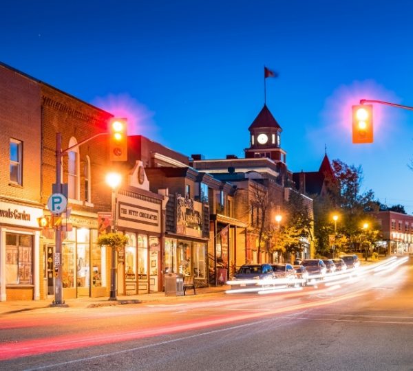 Straße in Huntsville mit Geschäften und beleuchteten Ampeln bei Nacht.