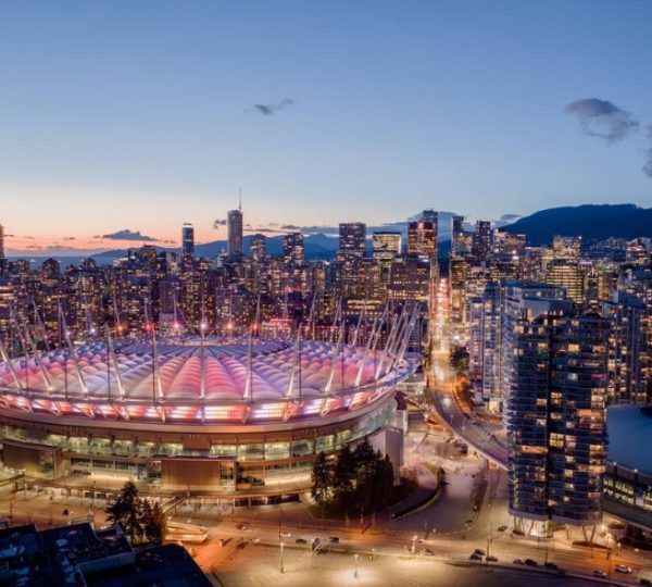 BC Place Stadion in Vancouver mit beleuchtetem Dach und umliegender Stadtansicht bei Dämmerung. Kanada-Rundreise