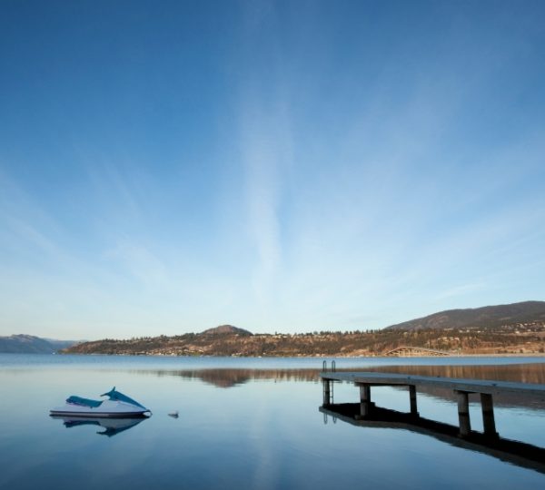 Ein Ruderboot liegt am Steg, während sich der Himmel über ruhigem Wasser erstreckt. Kanada-Rundreise