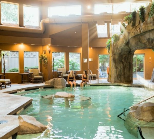 Innenpool mit Felsen, Pflanzen und Sitzbereichen in einem Wellnessbereich. Kanada-Rundreise