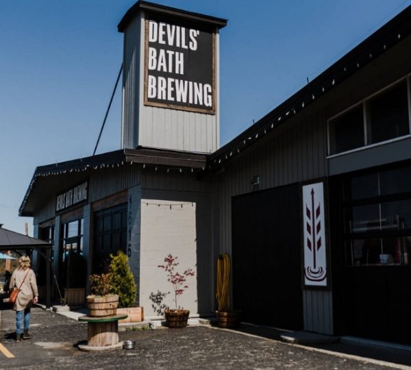 Fassade des Devil's Bath Brewing mit einem Schild und einer Person, die sich dem Eingang nähert. Kanada-Rundreise