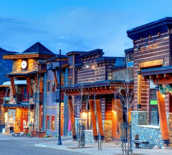 Moderne Holz- und Steinarchitektur von Geschäften in Big Sky, Montana, bei Dämmerung. Kanada-Rundreise