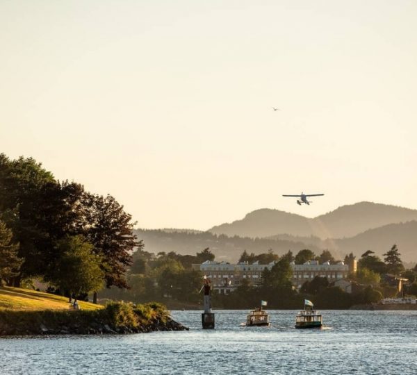 Ein Wasserflugzeug landet in Victoria, Vancouver Island, mit Bäumen und Bergen im Hintergrund. Kanada-Rundreise