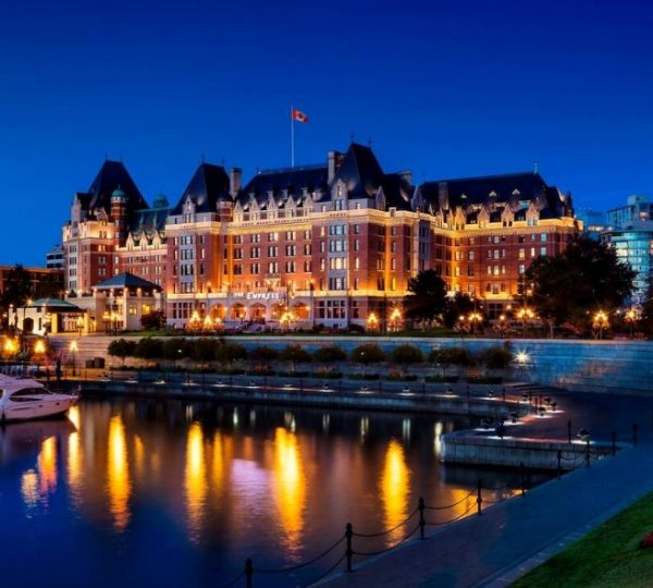 Fairmont Empress Hotel in Victoria, illuminated at night with reflections in the water. Kanada-Rundreise