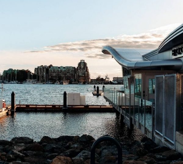 Blick auf das Wasser mit einem modernen Gebäude und Bootsanleger in Victoria, Vancouver Island. Kanada-Rundreise