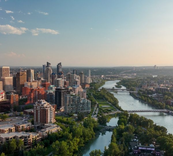 Luftaufnahme der Stadt Calgary mit dem Bow River und modernen Gebäuden im Vordergrund. Kanada-Rundreise