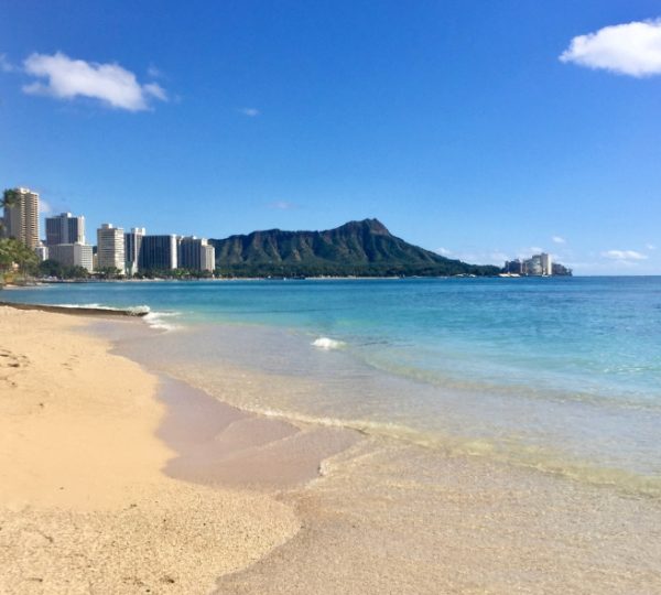 Strandansicht in Honolulu mit klarem Wasser und Diamond Head im Hintergrund. Kanada-Rundreise