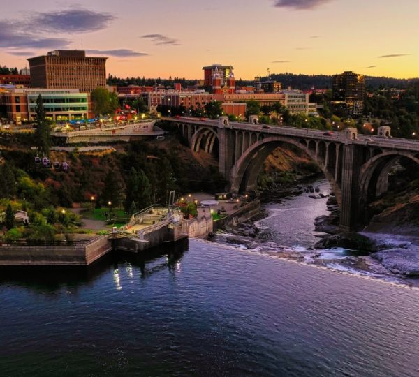 Brücke über den Spokane River mit städtischer Umgebung und Wasserfall im Hintergrund. Kanada-Rundreise