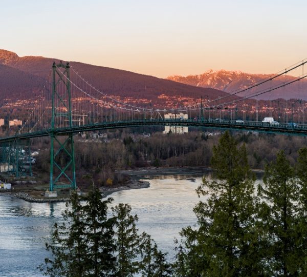 Lions Gate Bridge in Vancouver, spanning a body of water with mountains in the background. Kanada-Rundreise