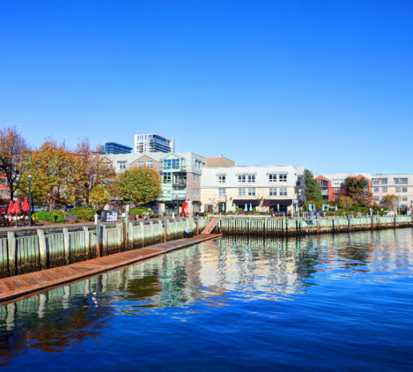 Hafenansicht von Halifax mit modernen Gebäuden und reflektierendem Wasser unter klarem Himmel. Kanada-Rundreise