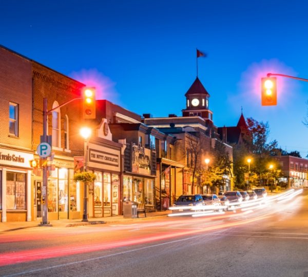 Nachtaufnahme einer Straße in Huntsville mit Geschäften und einem Uhrenturm im Hintergrund. Kanada-Rundreise