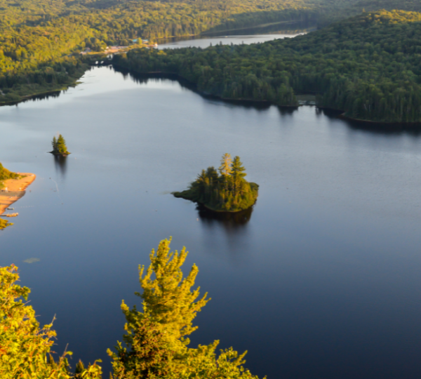 Panoramaansicht des Mont Tremblant Sees mit bewaldeten Ufern und kleinen Inseln im Wasser. Kanada-Rundreise