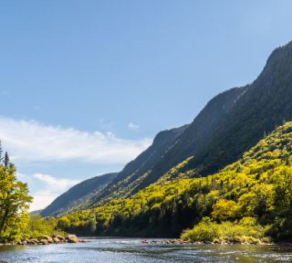 Berglandschaft mit einem Fluss, umgeben von Bäumen und Bergen im Osten Kanadas. Kanada-Rundreise