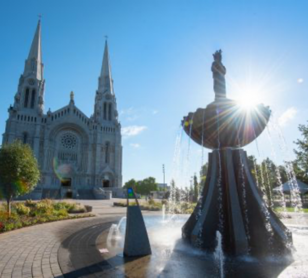 Kathedrale mit zwei Türmen und Springbrunnen im Vordergrund, Sonnenstrahlen hinter der Kathedrale. Kanada-Rundreise