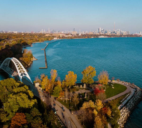 Luftaufnahme der Skyline von Toronto mit Wasser, Brücke und herbstlichen Bäumen im Vordergrund. Kanada-Rundreise