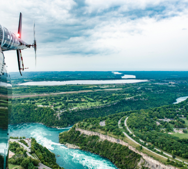 Luftaufnahme der Niagarafälle mit Blick auf den Fluss und die umliegende Landschaft aus einem Hubschrauber. Kanada-Rundreise