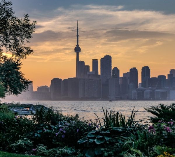 Skyline von Toronto mit dem CN Tower und Wolkenkratzern während des Sonnenuntergangs am Wasser. Kanada-Rundreise