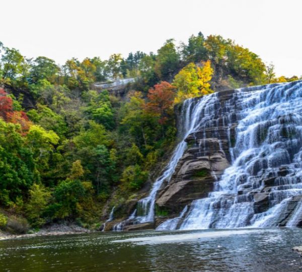Wasserfall in Ithaca mit fließendem Wasser und umgebender grüner Vegetation im Herbst. Kanada-Rundreise