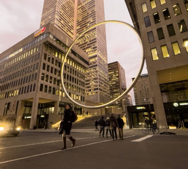 Moderne Skulptur in Form eines Rings vor Hochhäusern in Montreal bei Dämmerung. Kanada-Rundreise