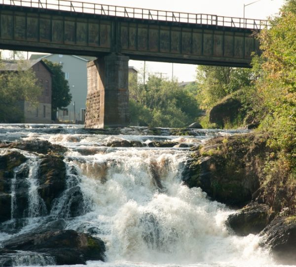 Wasserfall mit fließendem Wasser unter einer Brücke in einer natürlichen Umgebung. Kanada-Rundreise
