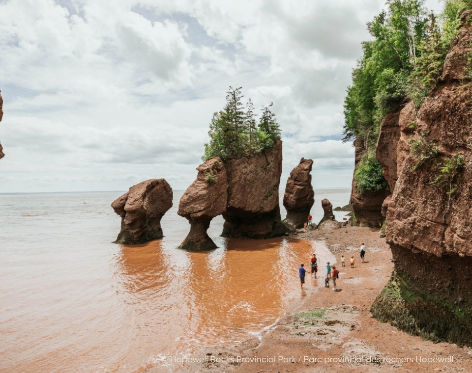 Hopewell Rocks im Hopewell Rocks Provincial Park mit markanten Felsen und Besuchern am Strand bei Ebbe. New Brunswick