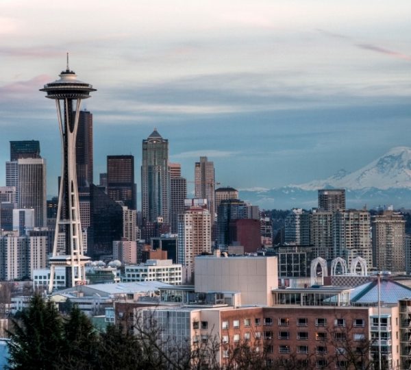 Blick auf die Seattle Skyline mit Space Needle, modernen Hochhäusern und dem schneebedeckten Mount Rainier im Hintergrund, urbanes Panorama der Hafenstadt Kanada-Rundreise