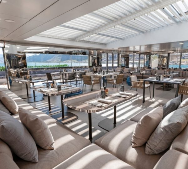 Luxuriöses Dining-Deck der Scenic Eclipse mit großen Fenstern, bequemen Sitzgelegenheiten, modernen Tischen und Blick auf das Meer, helles, offenes Interieur und Panorama-Aussicht Kanada-Rundreise