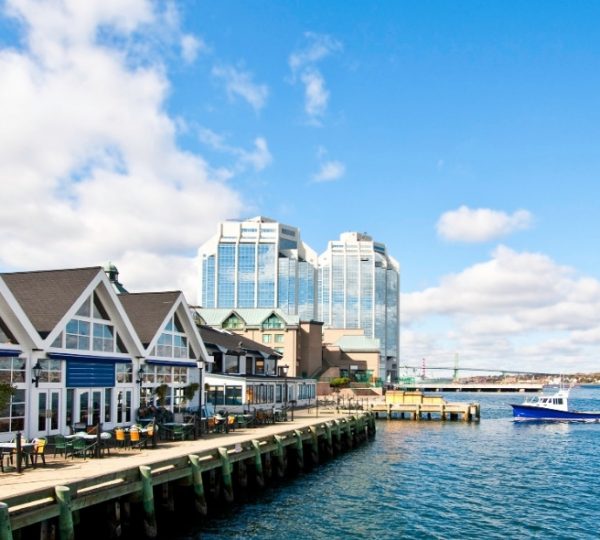 Scenic Eclipse Hafenlandschaft mit blauem Wasser, moderne Gebäude am Ufer, ruhiger Pier, klare Wolken am Himmel Kanada-Rundreise