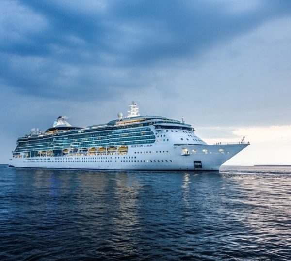 Rocky Mountaineer Bezug: Großes weißes Kreuzfahrtschiff liegt ruhig auf dem offenen Meer unter einem bedeckten Himmel, klare Wasseroberfläche, maritime Szene Kanada-Rundreise