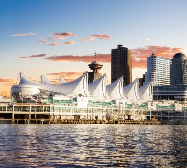 Sonnenuntergang über den Vancouver Hafen mit dem markanten Canada Place Segeldach und der Skyline am Ufer, das Wasser reflektiert den Himmel Kanada-Rundreise