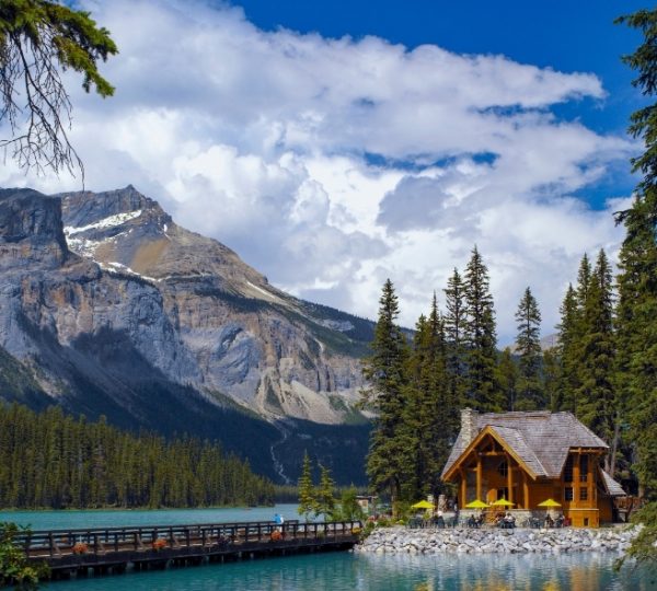 Emerald Lake im Yoho-Nationalpark mit türkisfarbenem Wasser, von Bergen umgeben, und einem rustikalen Holzhaus am Seeufer Kanada-Rundreise