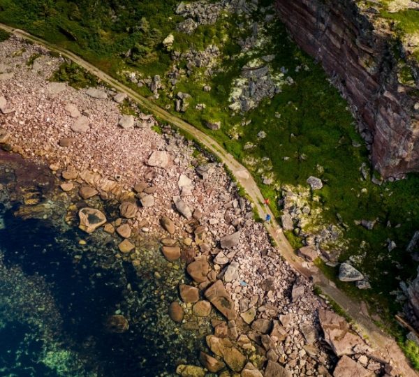 L'Anse-au-Clair felsige Küstenlinie am Meer, Klippenlandschaft aus der Luft, grüne Uferbereiche, klarblaues Wasser, Drohnenaufnahme Kanada-Rundreise