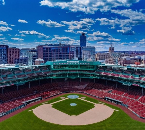 Boston Fenway Park mit roten Sitzreihen, grünem Baseballfeld und klarem blauen Himmel; sichtbare Stadionat-Architektur in der Skyline Kanada-Rundreise