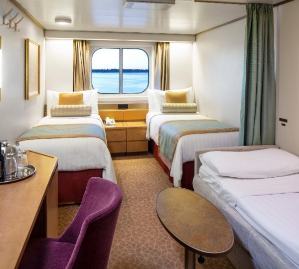 Kabine auf der Zuiderdam mit zwei Einzelbetten, gelb- und mintfarbene Akzente, Vorhänge, Fenster mit Meerblick, gemütliche Sitzecke und Telefondienst – Holland America Line Kreuzfahrt Kanada-Rundreise