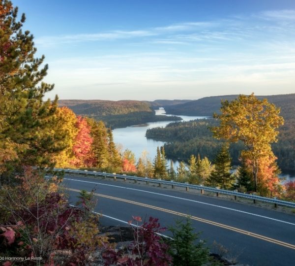 Blick auf die Rivière Saint-Maurice bei Saint-Jean-des-Piles: asphaltiertes Straßengefühl, buntes Herbstlaub und eine ruhige blaue Flusslandschaft in Québec. Kanada-Rundreise