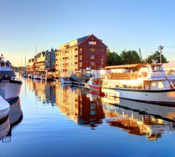 Hafen in Portland, Maine mit mehreren Booten, reflektierenden Wassern, historischen Gebäuden am Ufer und warmem Sonnenlicht, Portland-Blick Kanada-Rundreise