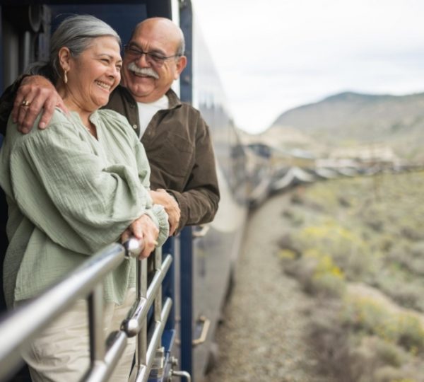 Entspanntes Paar am Panoramafenster im Rocky Mountaineer, Blick auf die bergige Landschaft rund um Banff mit klarer, frischer Weite in Kanada Kanada-Rundreise
