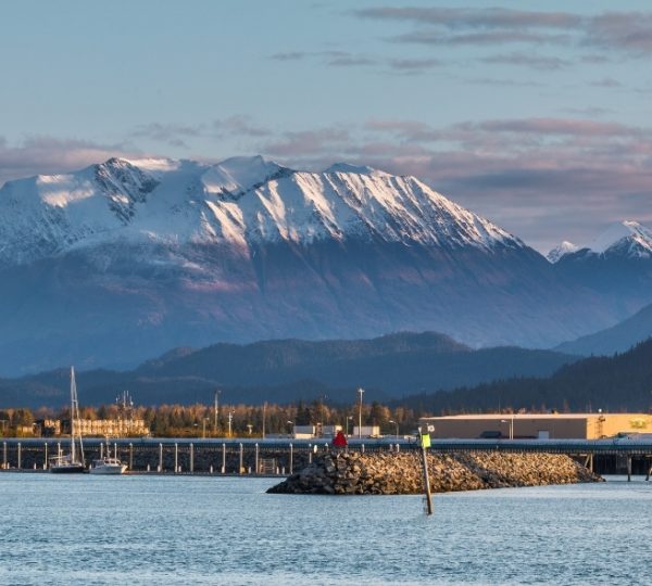 Seward in Alaska: Schnee bedeckte Bergketten über ruhigem Hafen, Segelboote am Kai, Panorama der Küstenlandschaft und klare Wasserreflektionen Kanada-Rundreise